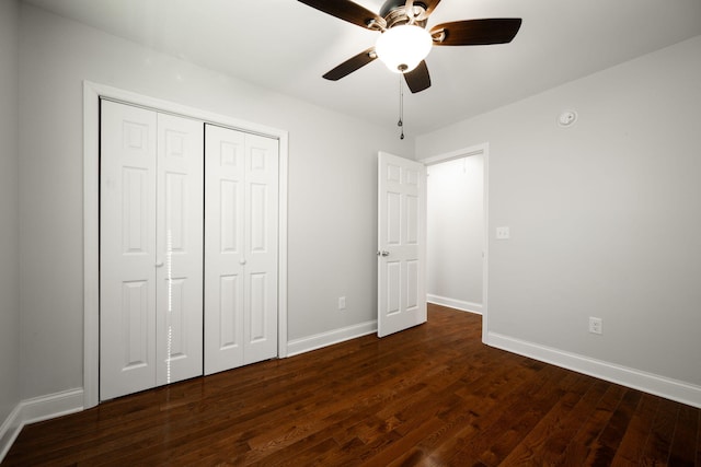 unfurnished bedroom with dark wood-type flooring, a closet, and ceiling fan