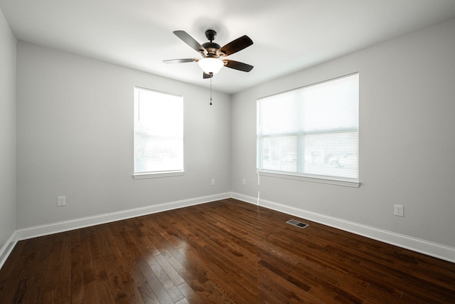 empty room with ceiling fan and dark hardwood / wood-style flooring