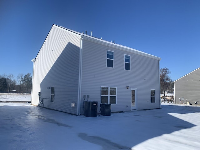 snow covered property with central air condition unit