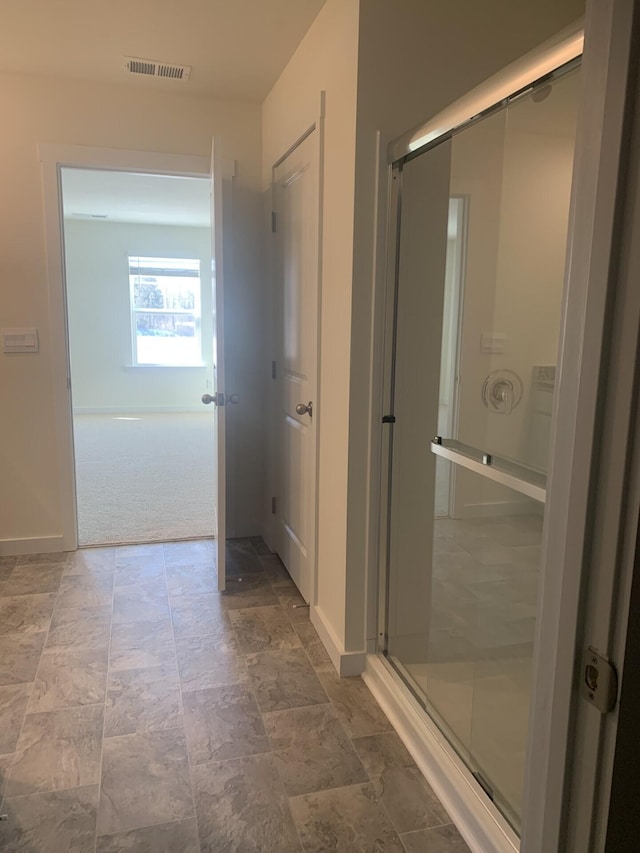 bathroom with a shower with door