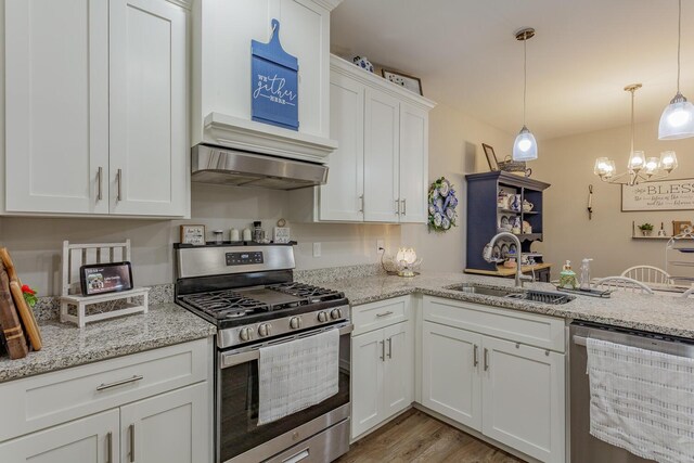 kitchen featuring sink, appliances with stainless steel finishes, white cabinetry, hanging light fixtures, and light stone countertops