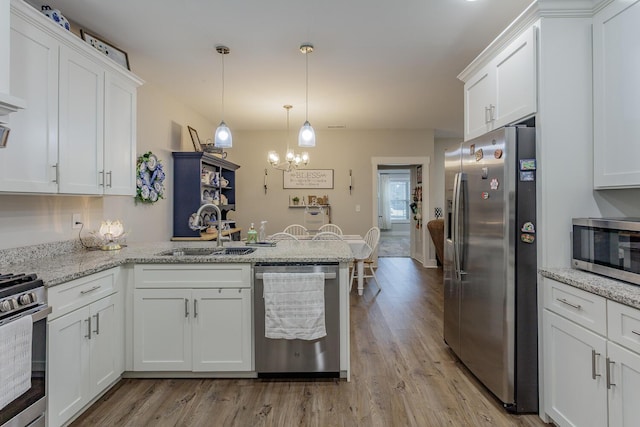 kitchen featuring sink, stainless steel appliances, white cabinets, and light stone countertops