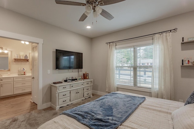 carpeted bedroom with ceiling fan and ensuite bath