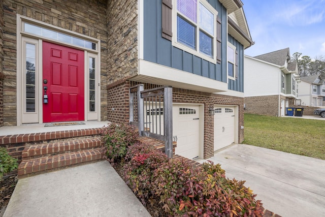 doorway to property with a garage and a yard