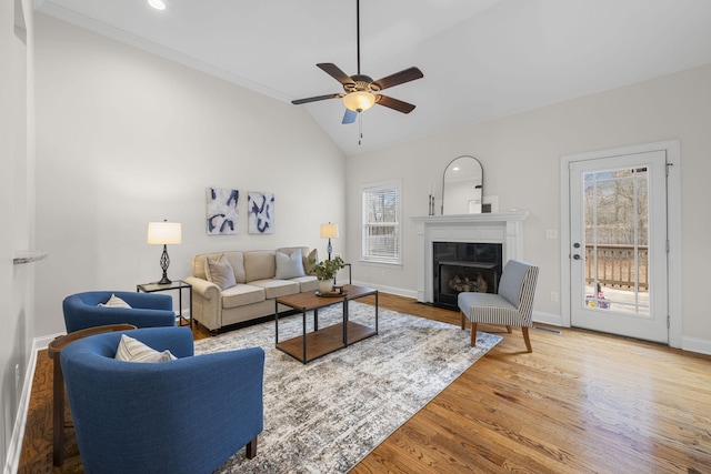 living room with wood-type flooring, lofted ceiling, and ceiling fan