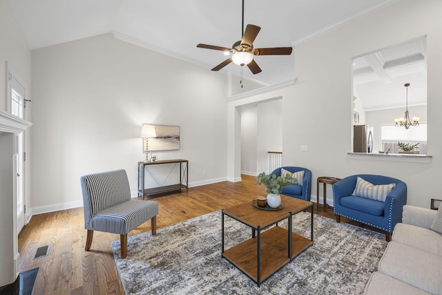 living room featuring ceiling fan with notable chandelier, hardwood / wood-style floors, vaulted ceiling with beams, coffered ceiling, and crown molding