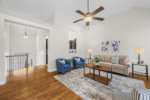 living room featuring hardwood / wood-style flooring, crown molding, and vaulted ceiling