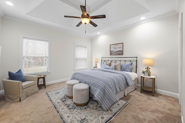 carpeted bedroom featuring a tray ceiling, ornamental molding, and ceiling fan