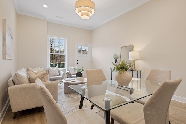 dining area featuring crown molding and light hardwood / wood-style floors