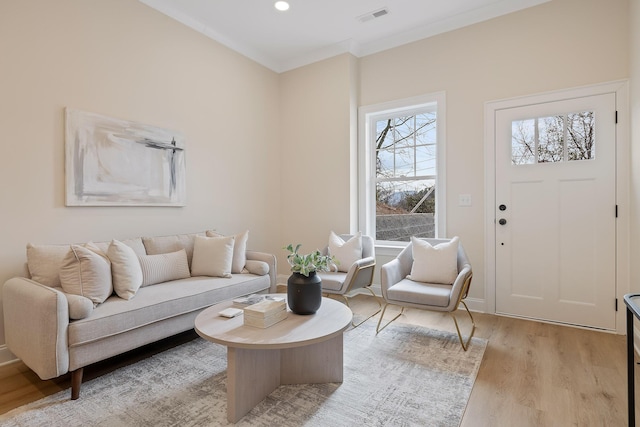 living room featuring crown molding and light hardwood / wood-style floors