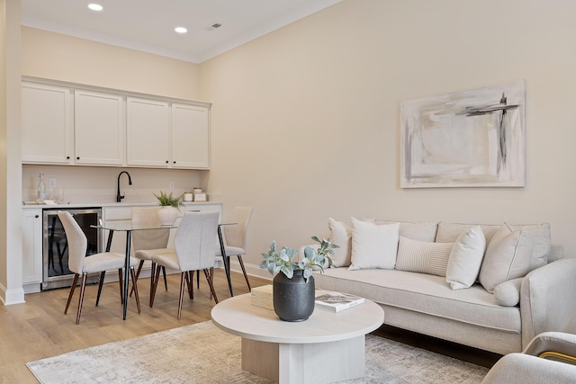 living room featuring light hardwood / wood-style flooring, wet bar, and beverage cooler