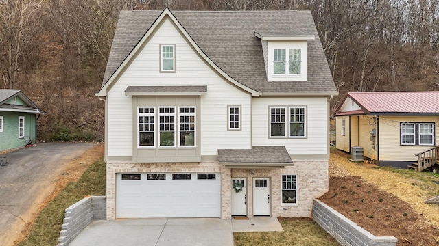 view of front of house with a garage and central air condition unit