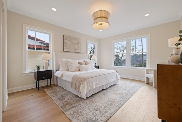 bedroom with ornamental molding and light hardwood / wood-style flooring