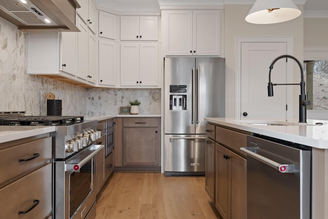 kitchen featuring white cabinetry, sink, high end appliances, and premium range hood