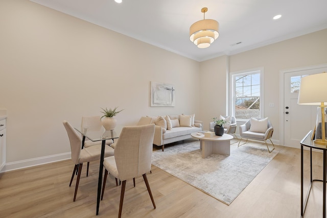 living room with crown molding and light wood-type flooring