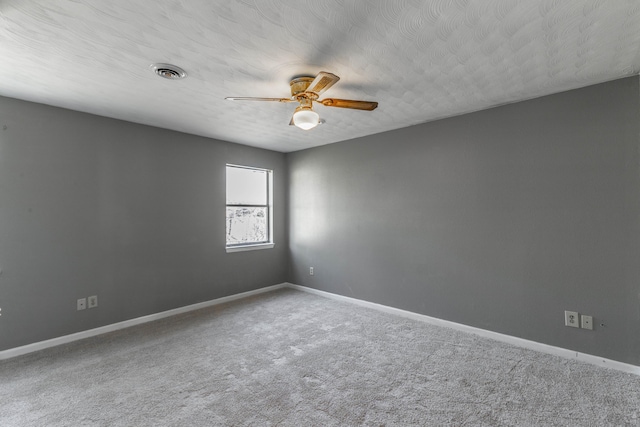 unfurnished room with ceiling fan, carpet, and a textured ceiling