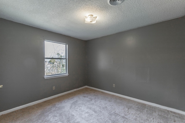 carpeted empty room with a textured ceiling