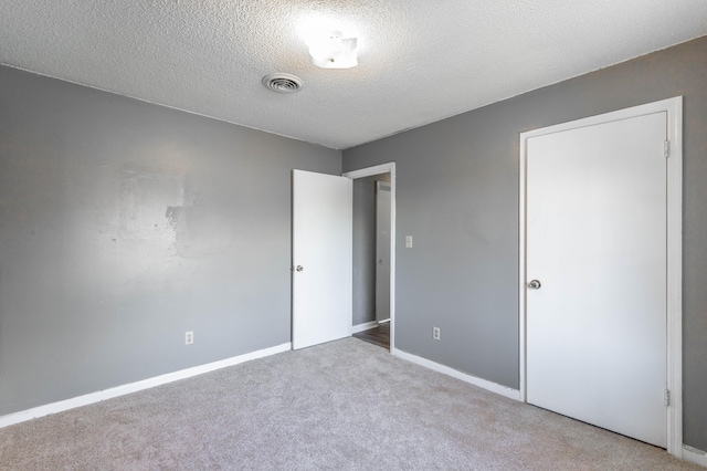 interior space featuring light colored carpet and a textured ceiling