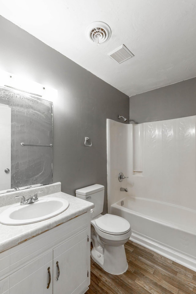 full bathroom featuring hardwood / wood-style flooring, vanity, toilet, and shower / bath combination