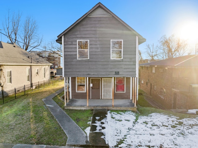 snow covered rear of property featuring a lawn and a patio area