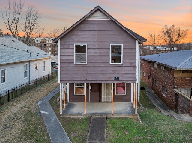 back house at dusk with a yard and a patio