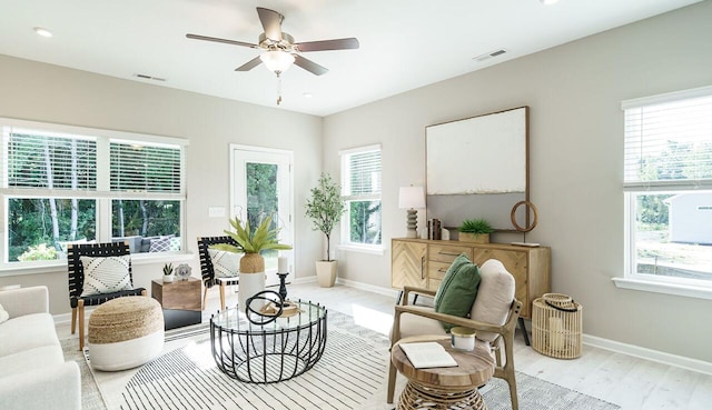 living area featuring light hardwood / wood-style floors and ceiling fan