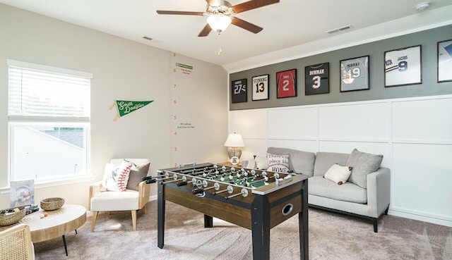 recreation room with light carpet and ceiling fan