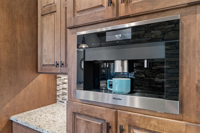 kitchen with light stone counters and backsplash