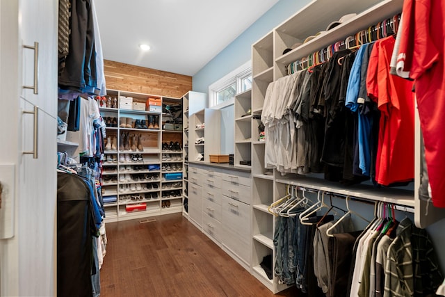 spacious closet with dark hardwood / wood-style flooring