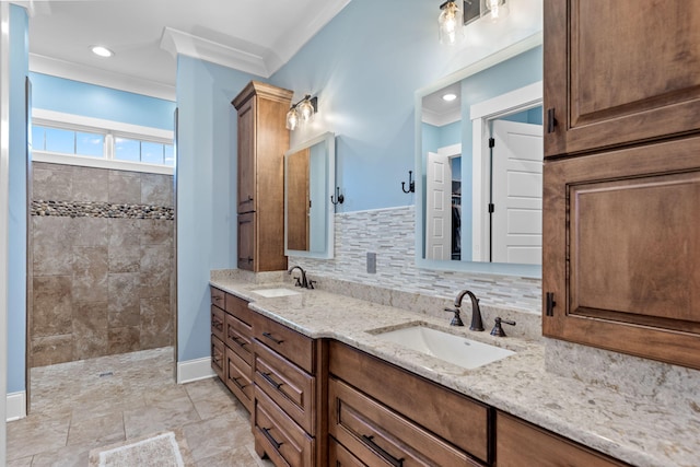 bathroom with vanity, crown molding, decorative backsplash, and a tile shower