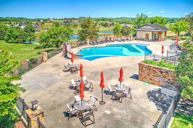 view of swimming pool featuring a patio and a water view