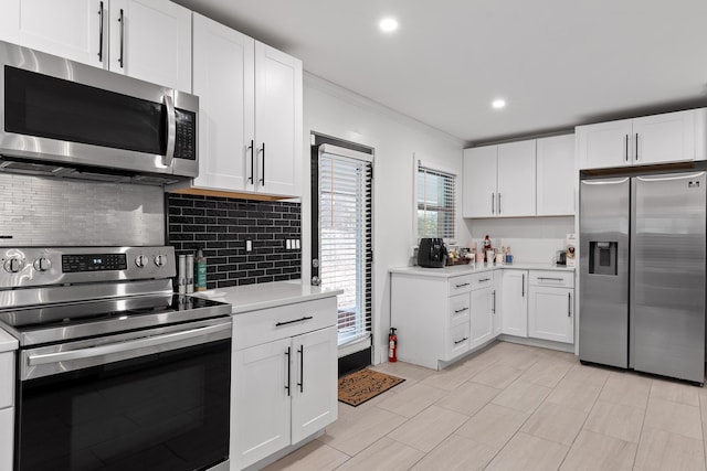 kitchen with appliances with stainless steel finishes, white cabinets, and decorative backsplash