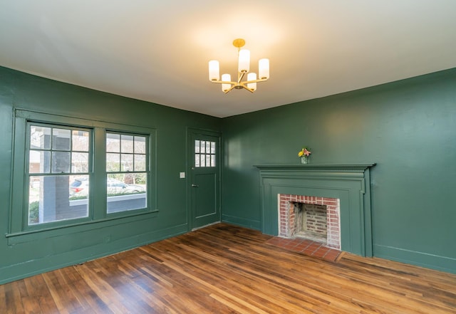 interior space featuring an inviting chandelier, a fireplace, and hardwood / wood-style floors