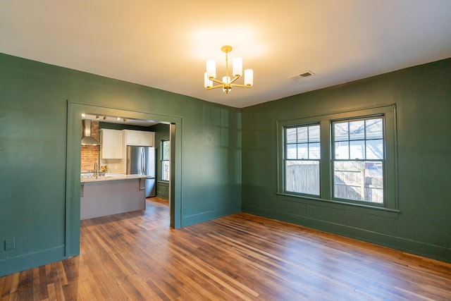 unfurnished room with dark hardwood / wood-style flooring and an inviting chandelier