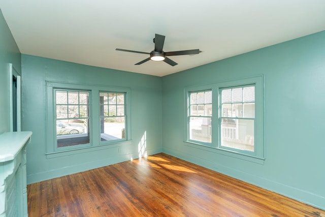 spare room with dark hardwood / wood-style flooring, plenty of natural light, and ceiling fan