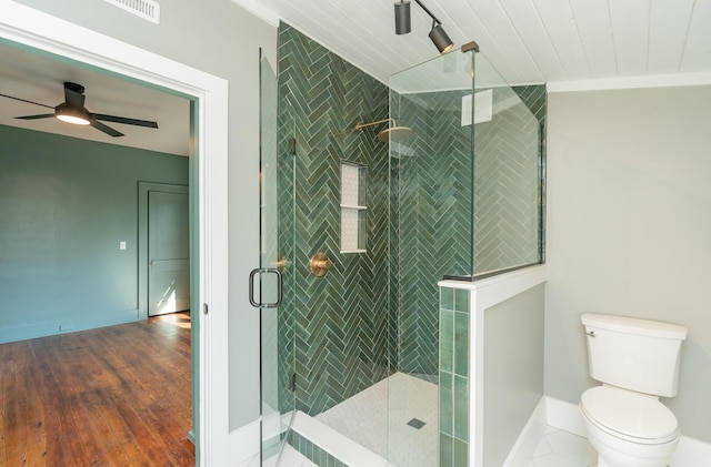 bathroom with an enclosed shower, ceiling fan, hardwood / wood-style flooring, and toilet