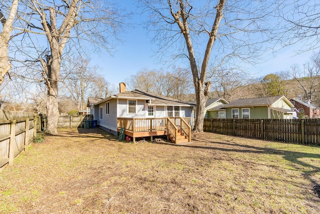 back of house with a lawn and a deck