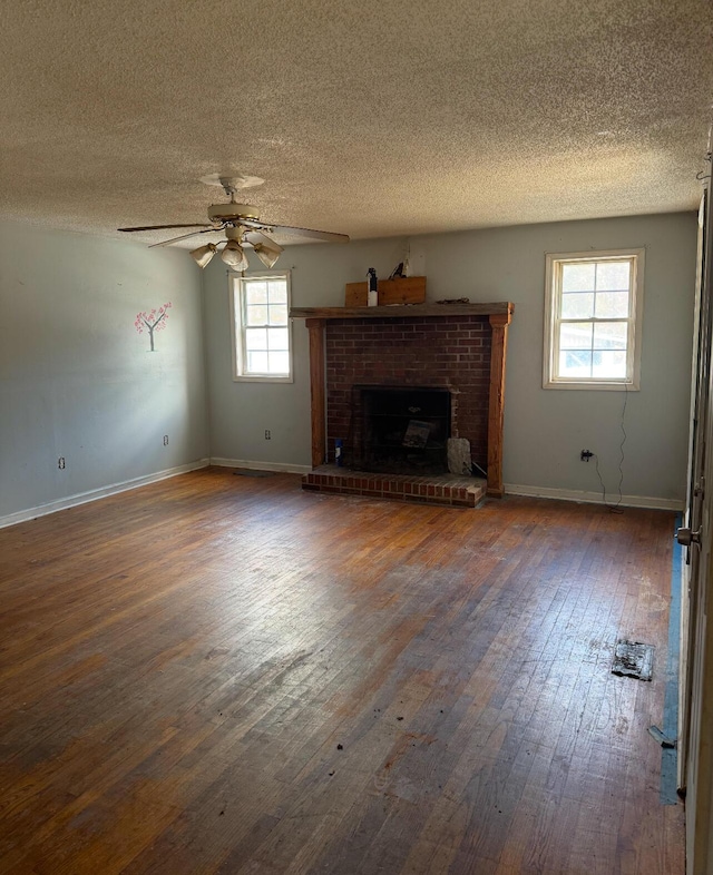 unfurnished living room featuring ceiling fan, dark hardwood / wood-style floors, a textured ceiling, and a fireplace