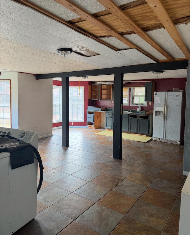 basement with washer / dryer and white fridge with ice dispenser