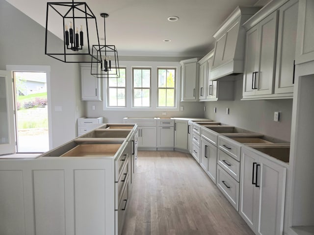 9892 Trestle Cir Unit 50, Ooltewah, TN 37363 - kitchen with a chandelier, light wood-style floors, a kitchen island, premium range hood, and hanging light fixtures