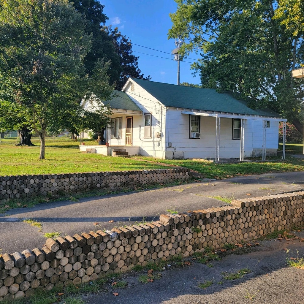 view of front of house featuring cooling unit and a front yard