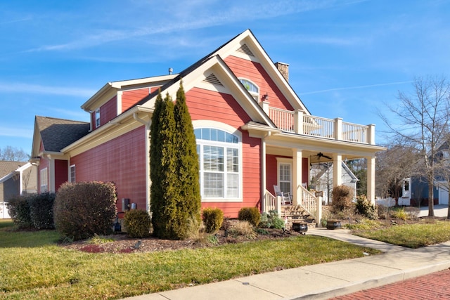 view of front facade featuring ceiling fan, a balcony, covered porch, and a front lawn