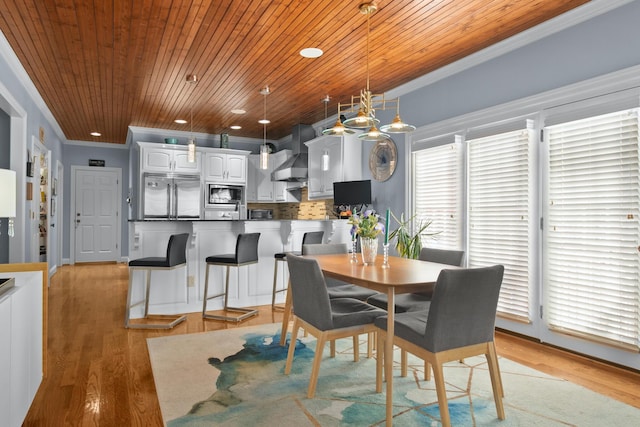 dining space featuring crown molding, wood ceiling, and light wood-type flooring