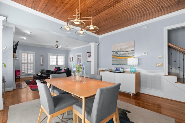 dining room with crown molding, hardwood / wood-style flooring, wooden ceiling, and decorative columns