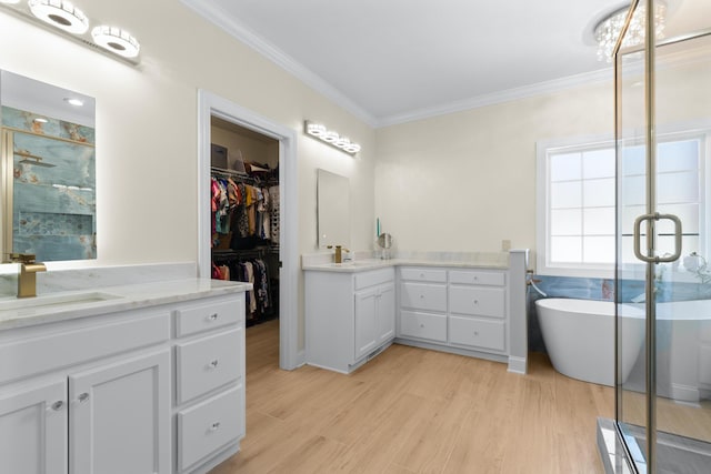 bathroom featuring ornamental molding, separate shower and tub, hardwood / wood-style floors, and vanity