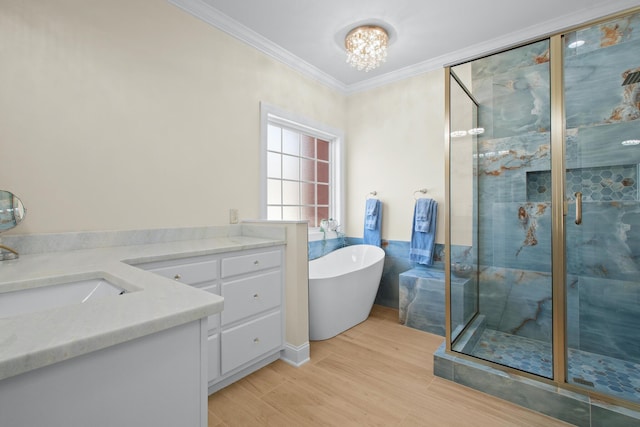 bathroom featuring an inviting chandelier, hardwood / wood-style floors, vanity, ornamental molding, and independent shower and bath