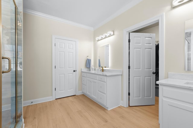 bathroom with hardwood / wood-style flooring, ornamental molding, vanity, and walk in shower