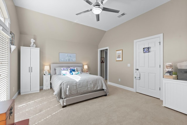 bedroom with vaulted ceiling, light colored carpet, and ceiling fan