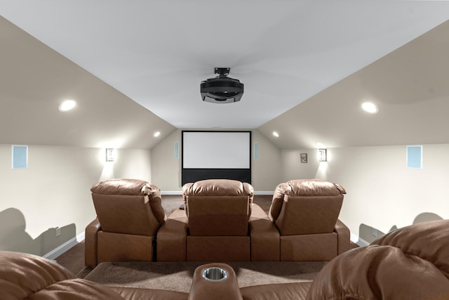 cinema room with vaulted ceiling and carpet