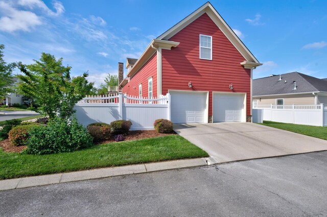 8625 Homecoming Dr, Chattanooga, TN 37421 - view of side of home featuring concrete driveway, a garage, and fence